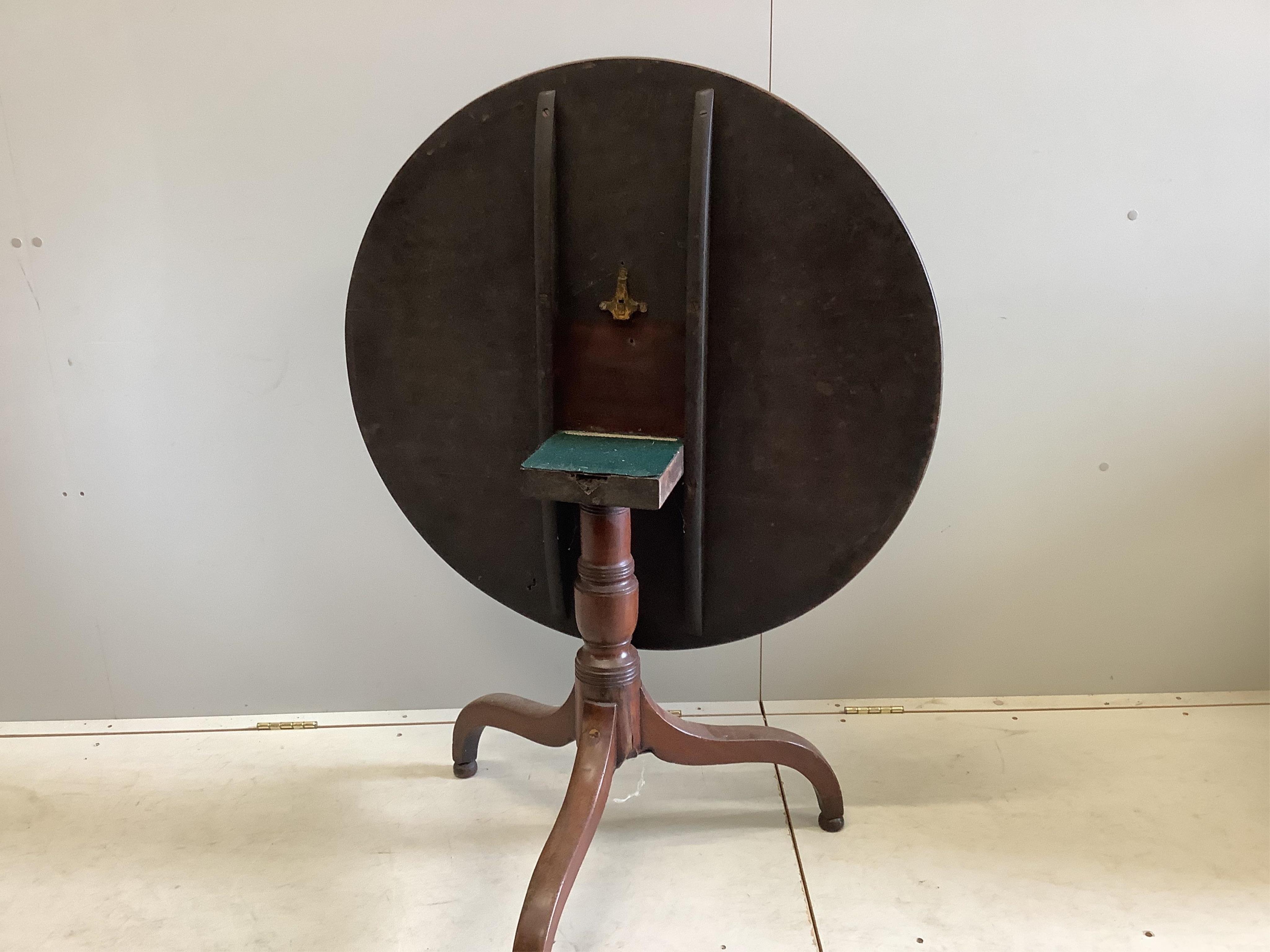 An early 19th century circular mahogany tilt top tripod tea table, diameter 86cm, height 67cm. Condition - fair